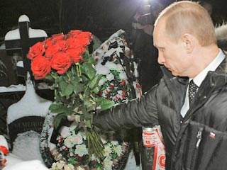 Речь идет о фотоснимке, распространенном агентством Reuters с Люблинского кладбища. Владимир Путин на фоне венков и ограды с повязанными на нее фанатскими шарфами протягивает свой букет роз