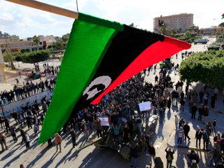 Такой же старый трехцветный национальный флаг, который существовал в Ливии до прихода к власти Муамара Каддафи, водрузили граждане США ливийского происхождения и ливийские дипломаты над посольством Джамахирии в Вашингтоне