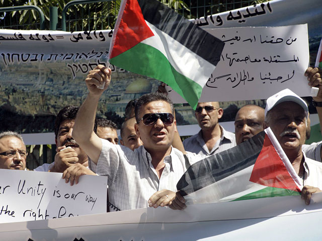 Более двух тысяч палестинцев собрались на площади Арафата в Рамаллахе перед огромным монитором, установленным на одном из домов в преддверии исторического выступления председателя ПНА Махмуда Аббаса в ООН