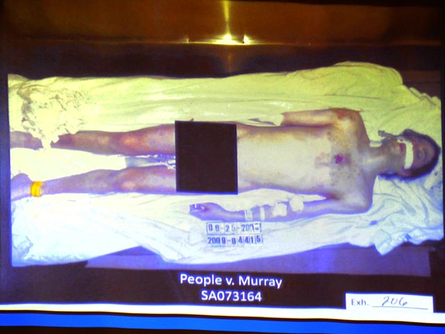 На фотографии запечатлено обнаженное тело певца, лежащего на белой простыне