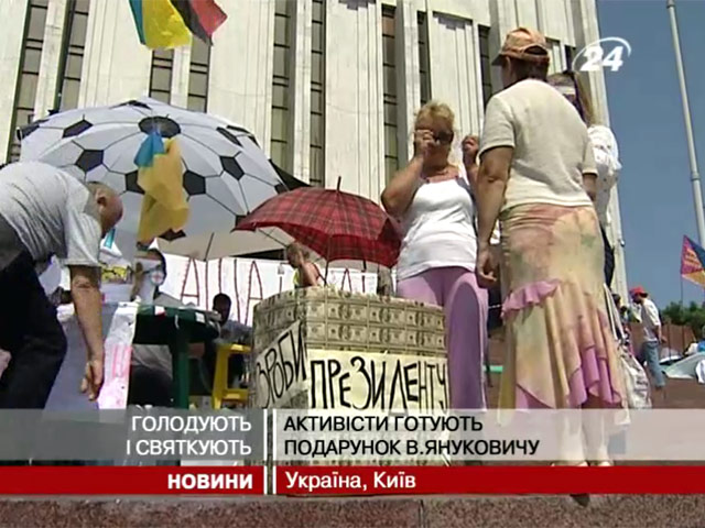 Активисты возле Украинского дома в Киеве провели перформанс "Подарок президенту". Они принесли большой чемодан, а также коробку, обклеенную ксерокопиями 100-долларовых купюр с надписями "президенту"