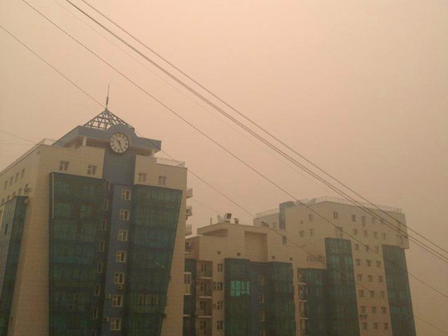 Густой смог от лесных пожаров окутал Якутск, в воздухе сильный запах гари, люди стараются не выходить на улицу, держат окна закрытыми при жаре в 34 градуса