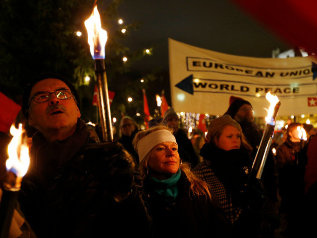 Противники присуждения Нобелевской премии мира Евросоюзу прошли маршем по центру Осло, сжимая в руках сотни факелов