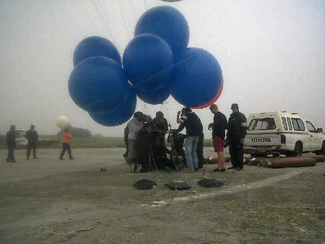 Житель Кейптауна в ЮАР сегодня предпринял необычный полет на заполненных гелием надувных шарах, чтобы пересечь Столовую бухту по воздуху от острова Роббен до парламентской столицы страны