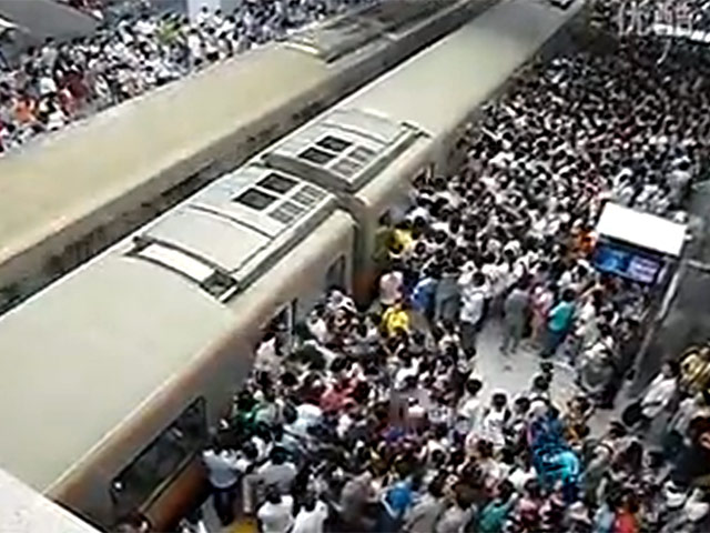 На записи видна толпа людей, ожидающих прибытие поезда. Как только состав подходит к перрону, пассажиры начинают "драку за места" в салоне