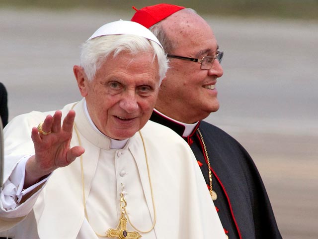 Кардинал Ортега (на заднем плане)подал заявление об отставке Папе Римскому Бенедикту XVI два года назад, как того требуют каноны Католической церкви, устанавливающий 75-летний возрастной лимит для всех епископов
