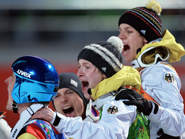 Спортсмены сборной Германии радуются победе в финале командных соревнований по прыжкам с большого трамплина (К-125) среди мужчин на ХХII Олимпийских играх в Сочи