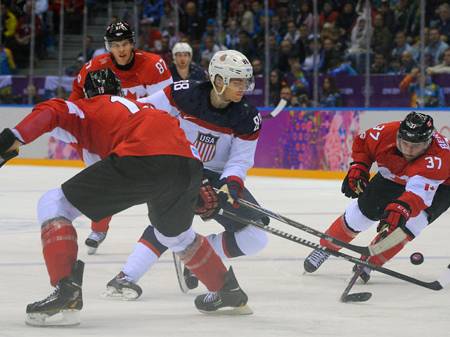 Слева направо: Джей Баумистер (Канада), Сидни Кросби (Канада), Патрик Кейн (США) и Патрис Бержерон (Канада) в полуфинальном матче между сборными командами США и Канады в соревнованиях по хоккею среди мужчин