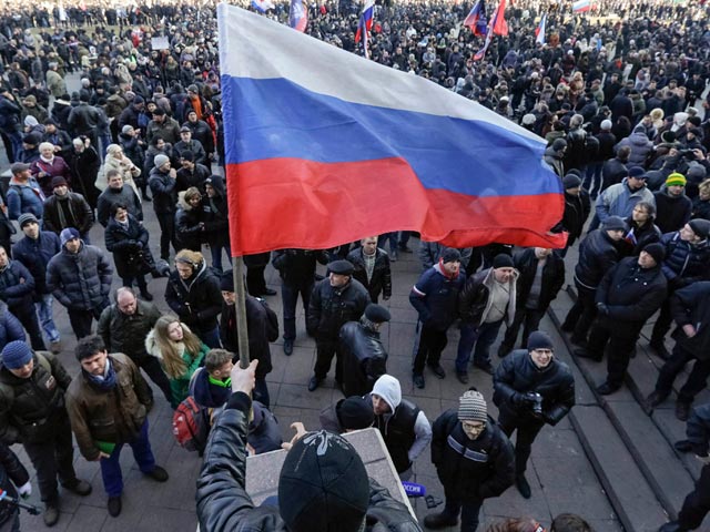 Участники акции скандируют: "Донбасс - Россия!", "Беркут!", "Фашизм не пройдет!" и "Путин помоги!". Они также держат российские и георгиевские флаги