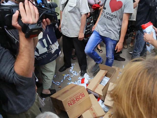 Коробки и пакеты с конфетами были раздавлены женщинами и мужчинами, собравшимися на площади
