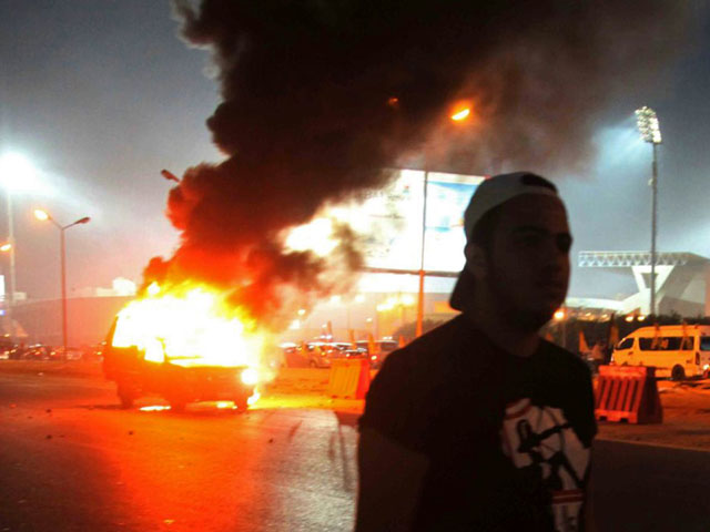 Глава МВД Египта заявил, что около десяти тысяч болельщиков попытались прорваться на арену без билетов. В итоге они сожгли как минимум два полицейских автомобиля