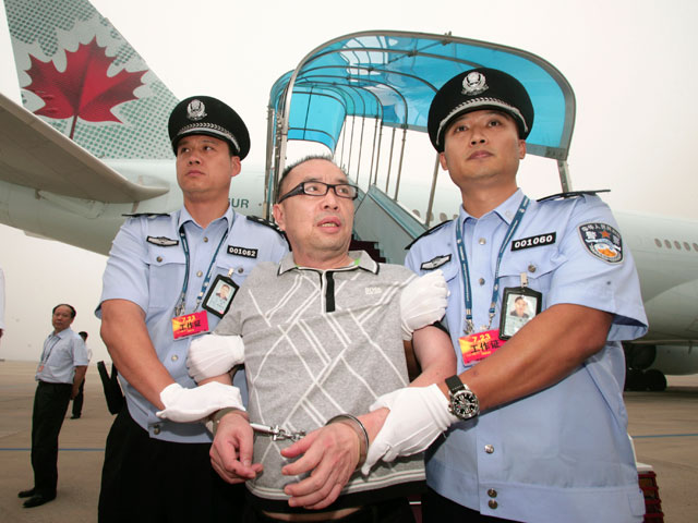 Китайского беглеца Лай Чансин сопровождают обратно в Пекин из Канады, Международный аэропорт, Пекин, 23 июля 2011 года