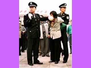 Китайские полицейские задерживают одного из участников акции протеста против преследований последеователей 'Фалуньгун'