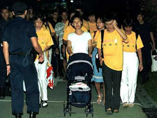 Члены общины "Фалуньгон" в сопровождении сингапурских полицейских