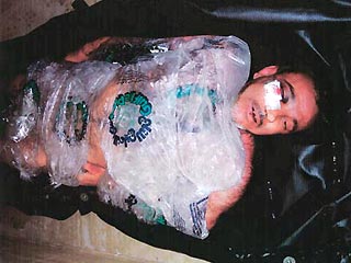 Тело погибшего Манаделя аль-Джамади было сфотографировано закутанным в целлофан, наполовину погруженным в лед и со стянутыми за спиной запястьями