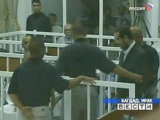 Саддам, которого сопровождали двое охранников, предстал перед судом в темном костюме, в белой рубашке, без галстука