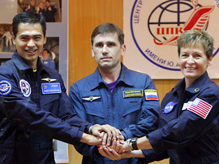 Три космонавта: русский Юрий Маленченко, американка Пегги Уилсон и Шейх Музафар Шукор из Малайзии отправились надевать скафандры