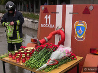 Коллеги погибших сотрудников МЧС почтили память восьми пожарных и принесли к сгоревшему зданию цветы