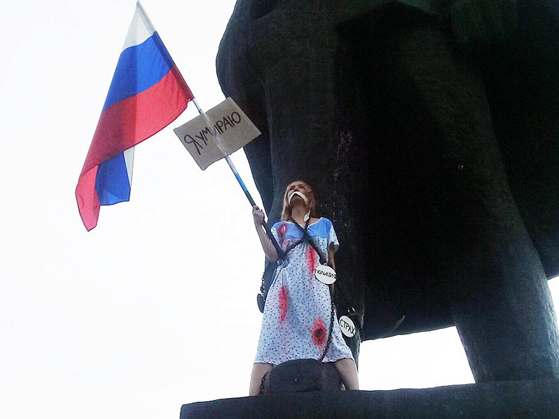 В Новосибирске студентка в ночнушке и с российским флагом приковала себя цепями к памятнику Ленина