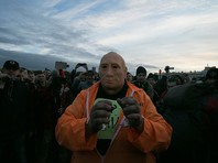 "ОВД-Инфо" называет Иванютенко уличным активистом, в публикации о нем приведено фото человека в маске Путина с плакатом на груди

