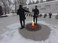 На фото в соцсети запечатлено, как у Вечного огня находятся двое мужчин, причем один из них стоит ногами на решетке вокруг огня и держит в руке бутылку