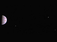 На цветном снимке, опубликованном NASA, виден Юпитер и три из его четырех крупнейших лун - Ио, Европа и Ганимед
