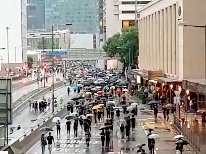 В Гонконге проходит новое шествие протестующих несмотря на дождь и запрет полиции

