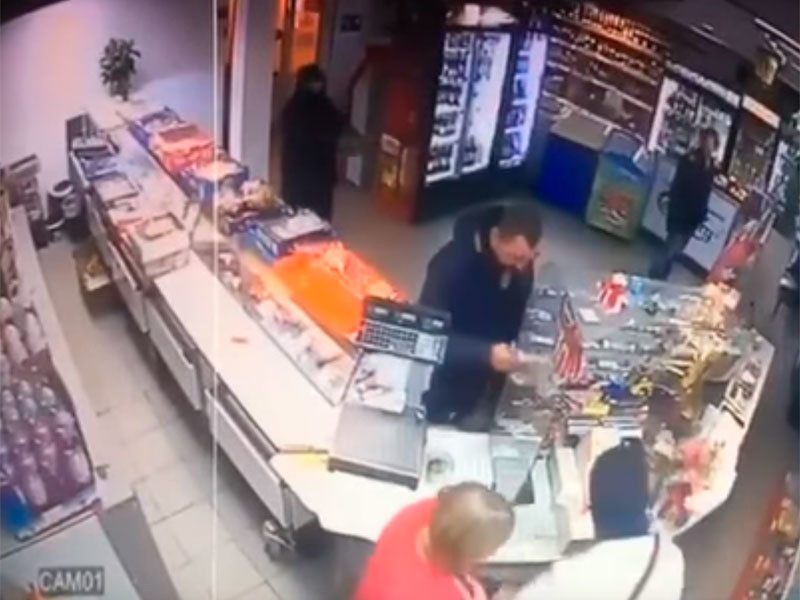 В продуктовый магазин ворвались два грабителя, скрывавшие лица под балаклавами. Один из них угрожал посетителям и персоналу пистолетом, а другой забежал за прилавок, чтобы похитить из кассы деньги