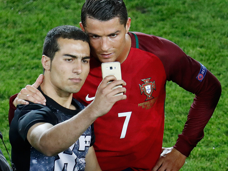 Капитан сборной Португалии по футболу Криштиану Роналду дал возможность сделать совместное с ним селфи болельщику, который прорвался на поле сразу после окончания матча группового этапа чемпионата Европы-2016 с командой Австрии
