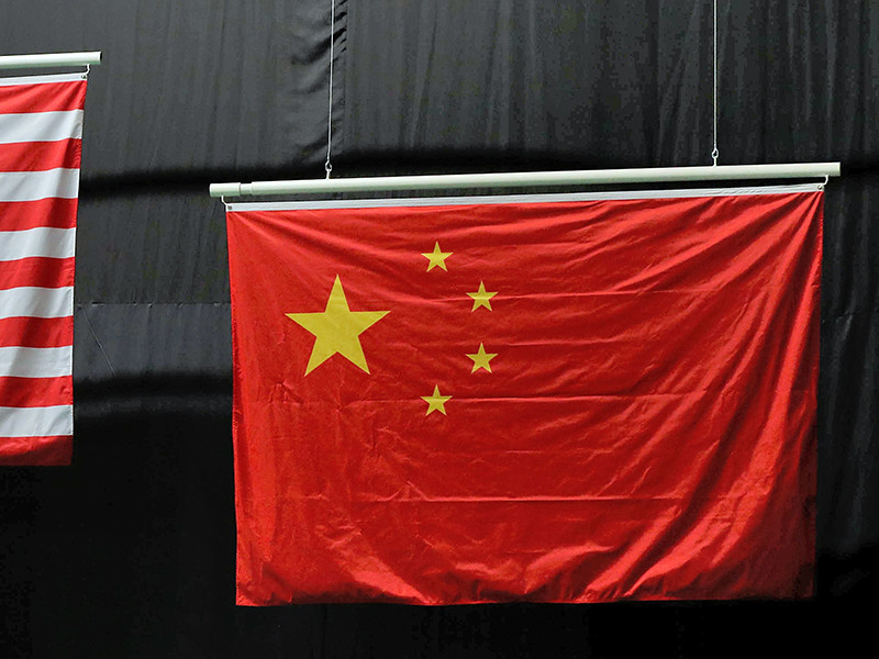 Государственный флаг КНР представляет собой красное полотно, в левом верхнем углу которого находится пятиконечная звезда, ее обрамляет дуга из четырех звезд меньшего размера. Лучи которых непременно должны указывать на большую, но на знаменах в Рио звезды расположены параллельно друг другу